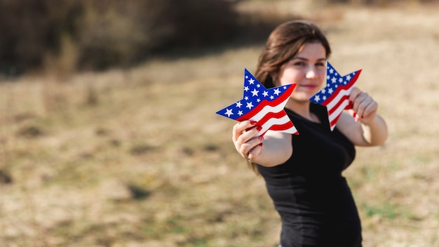 Free photo woman holding american flag stars and looking at camera