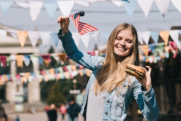 Free photo woman holding american flag and tasty burger