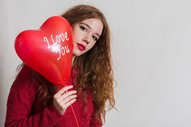 Woman holding a balloon close to her face