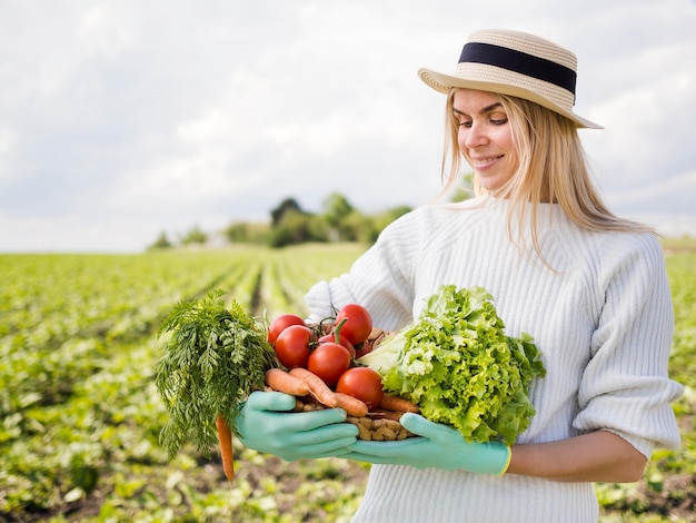 Woman holding a basket full of vegetables