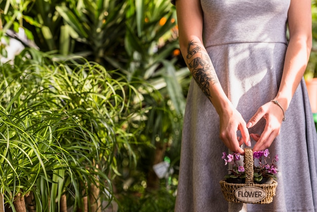 Free photo woman holding basket with flowers