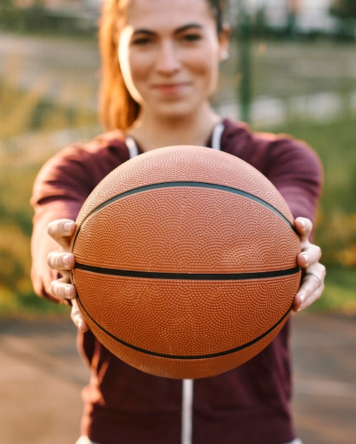 Woman holding a basketball in front of her