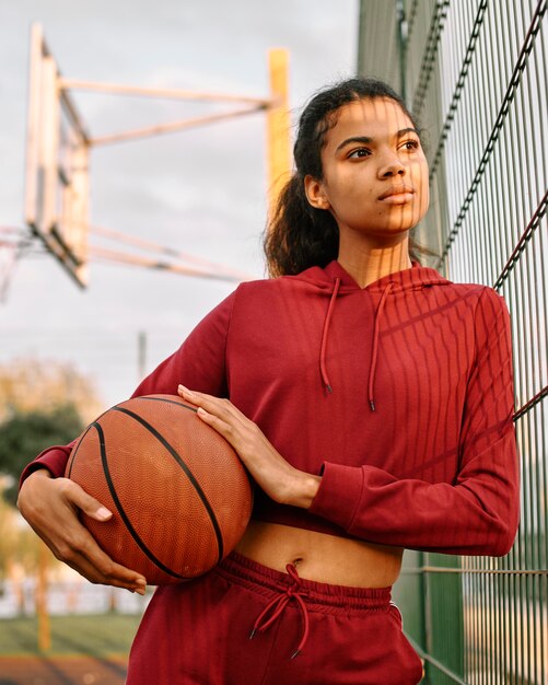 Woman holding a basketball outdoors