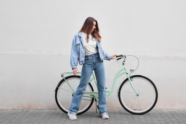 Woman holding the bike's handlebars outdoors