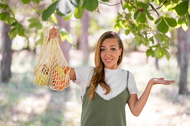 Woman holding a biodegradable bag with vegetables and fruits