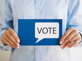 Free photo woman holding blue card with vote speech bubble