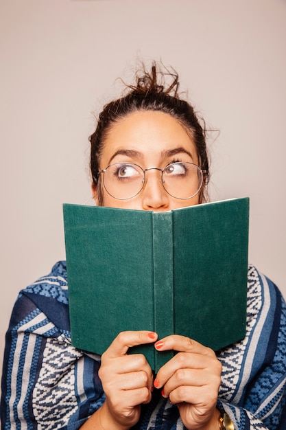 Free photo woman holding book in front of face