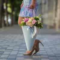 Free photo woman holding a bouquet of flowers in the street view