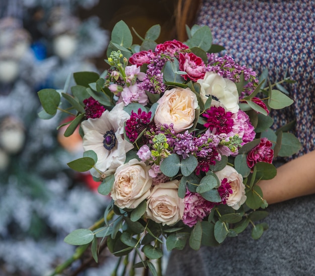 A woman holding a bouquet of pink and white flower set in the hand