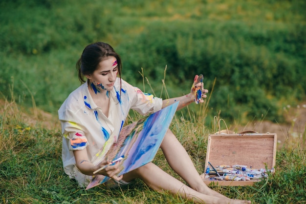 Woman holding a box with her legs while sitting on the floor