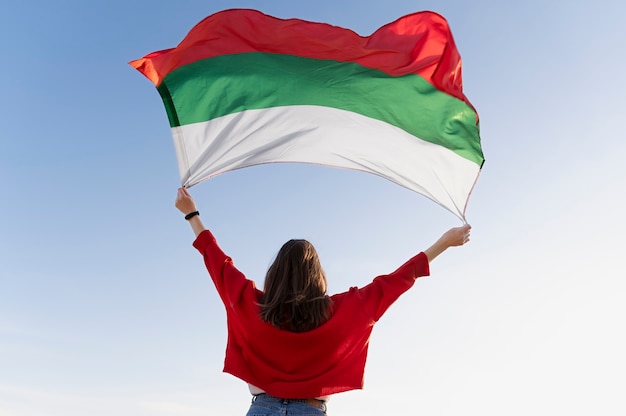 Woman holding bulgarian flag against the blue flag