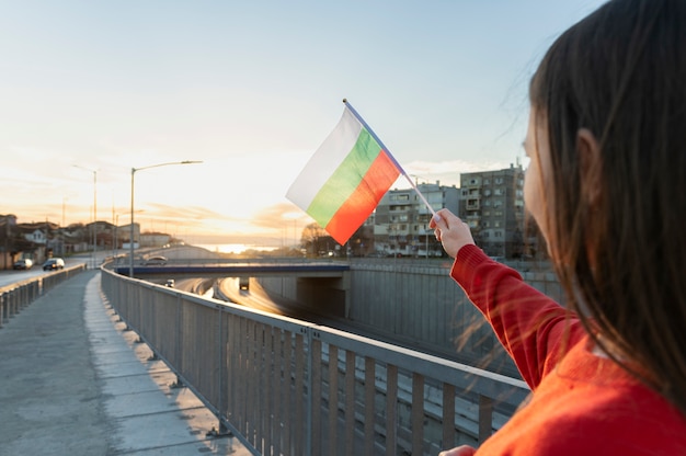 Woman holding bulgarian flag outdoors