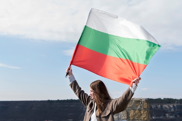 Free Photo woman holding bulgarian flag outdoors