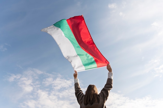 Free Photo woman holding bulgarian flag outside