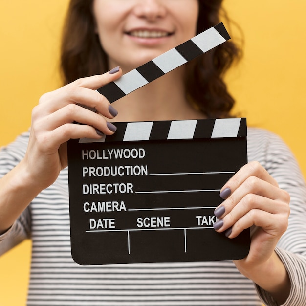 Woman holding a clapperboard close-up