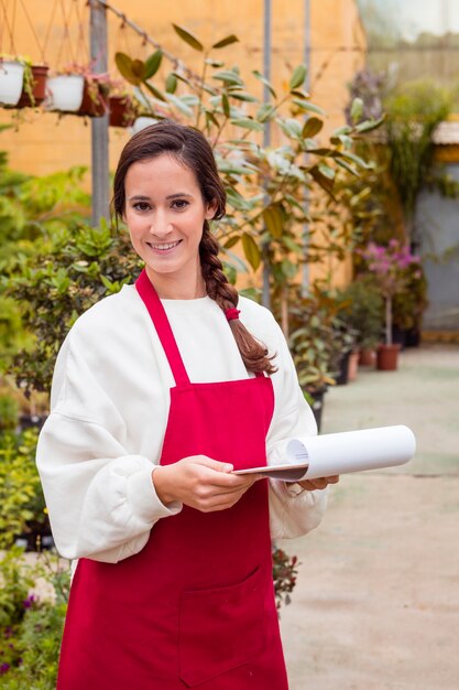 Woman holding clipboard in greenhouse