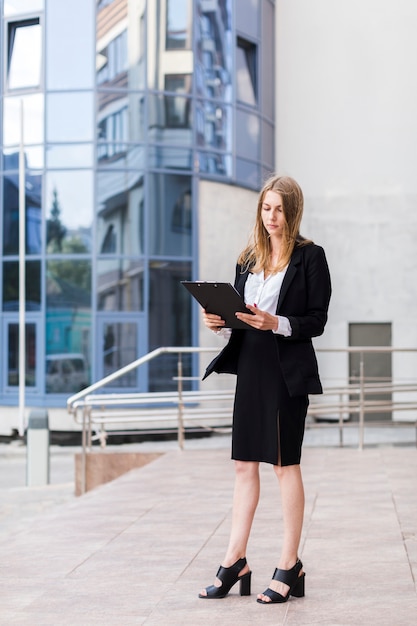 Woman holding a clipbord long shot