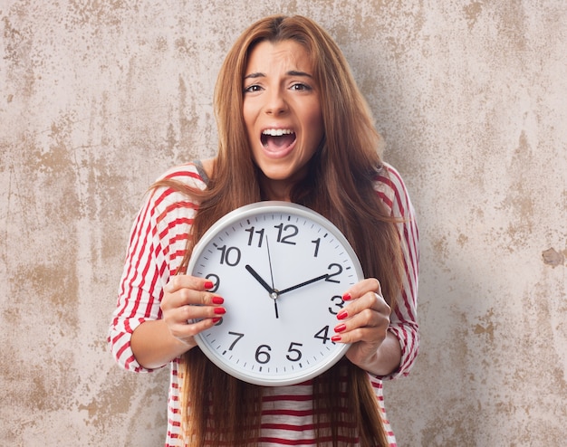 Free photo woman holding clock and screaming