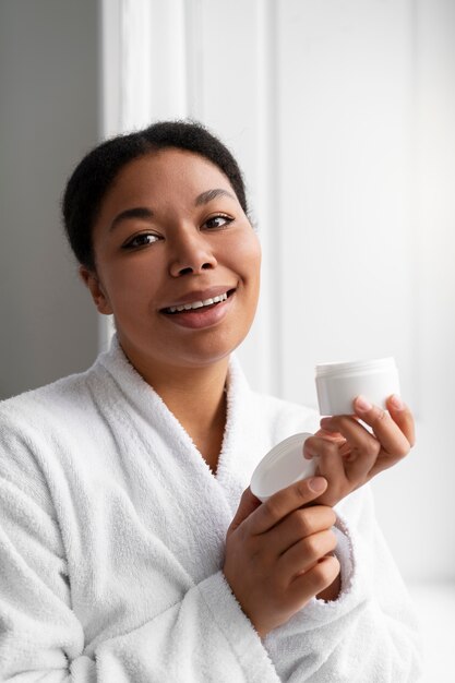 Woman holding cream container front view