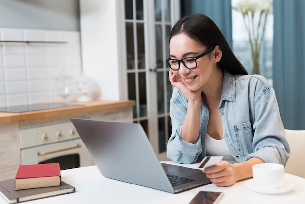 Woman holding credit card and shopping online on laptop