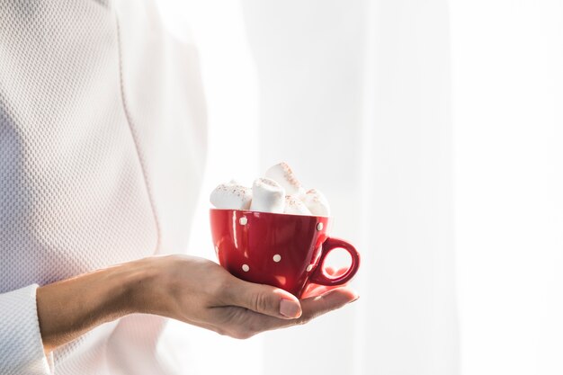 Woman holding cup with marshmallow