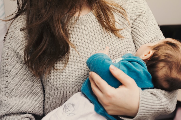 Woman holding cute baby in arms