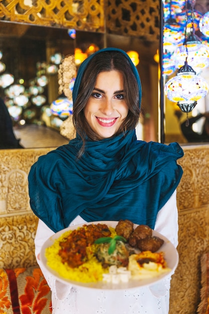 Free photo woman holding dish of arab food