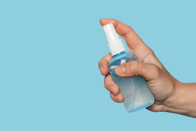 Free Photo woman holding a disinfectant bottle with copy space