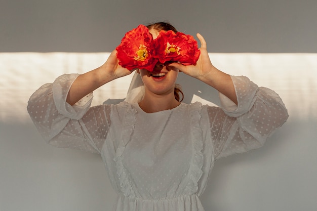 Free photo woman holding flowers over eyes