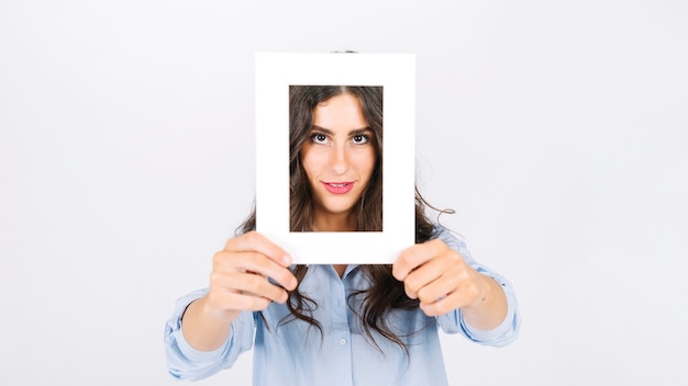 Woman holding frame in front of face