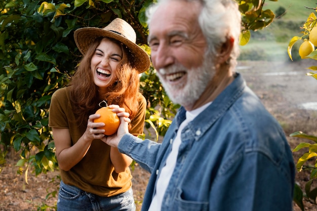 Free photo woman holding a fresh orange with her dad