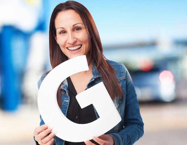 woman holding the G letter