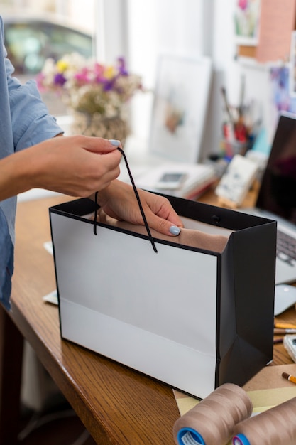 Woman holding gift bag on desk