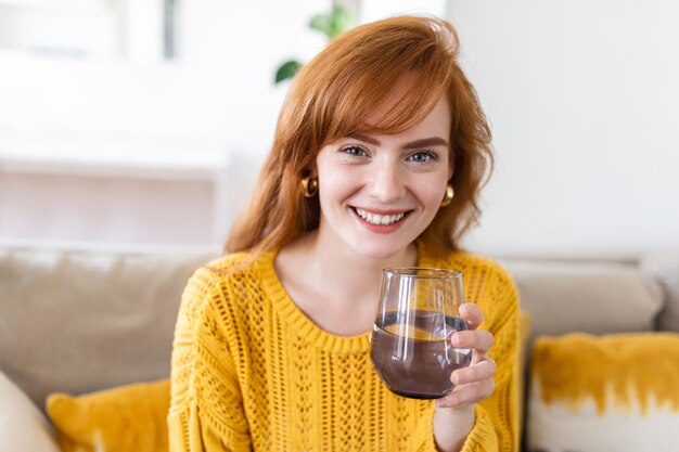 Woman holding glass drinking natural water Enough of quantity aqua improves skin complexion increases energy prevention of body dehydration healthy lifestyle concept