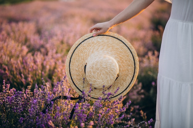 Free photo woman holding hat in a lavander field close up