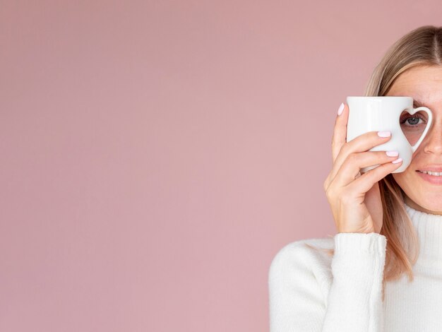 Woman holding heart mug copy space