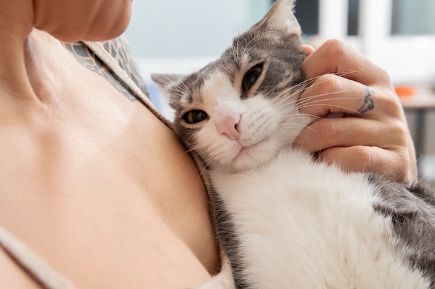 Free photo woman holding her adorable kitty at home