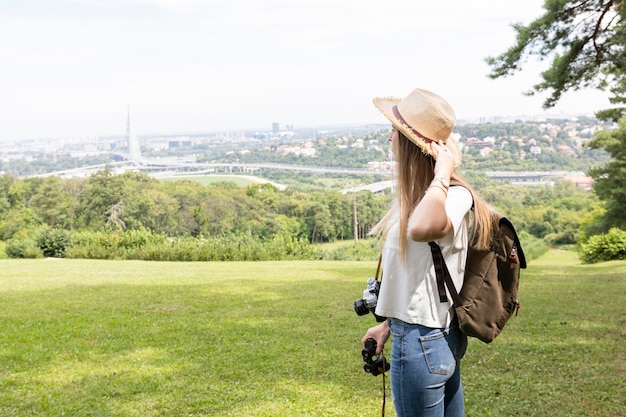 Woman holding her hat and looking away