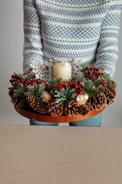 Free photo woman holding holiday themed wreath in her hands