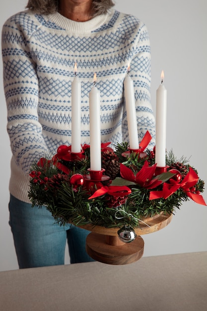 Free Photo woman holding holiday themed wreath in her hands