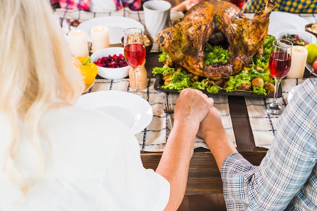 Woman holding human hand at table