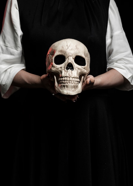 Woman holding human skull with copy space