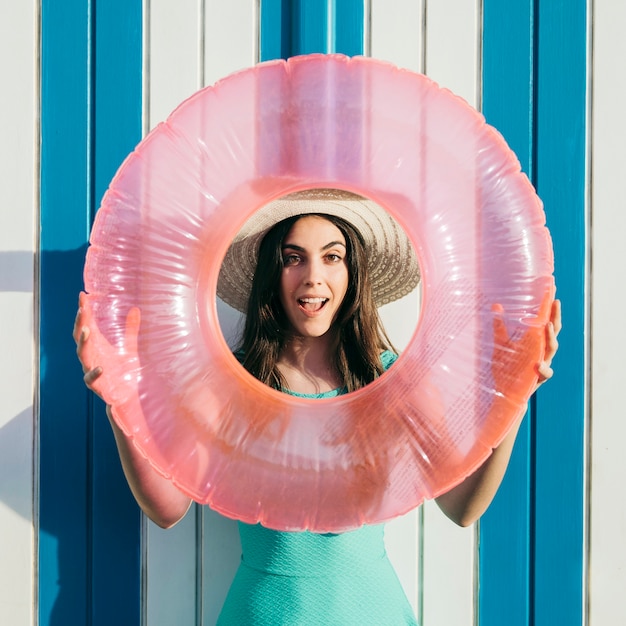 Free Photo woman holding inflatable ring around face