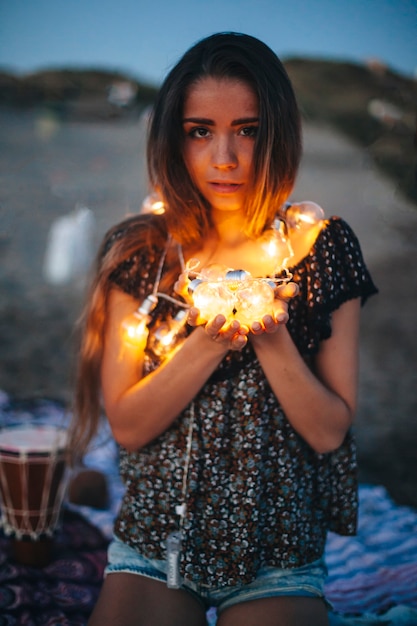 Free photo woman holding light bulb chain