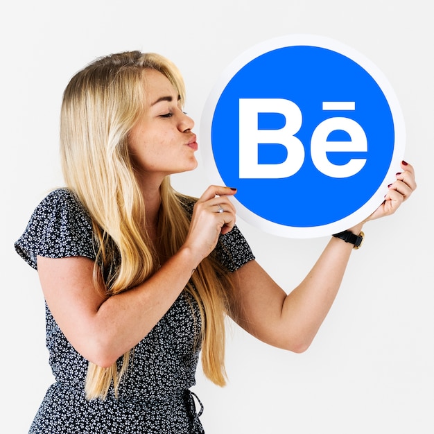 Woman holding a logo of Behance