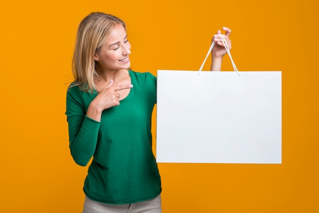 Free photo woman holding and looking at big shopping bag