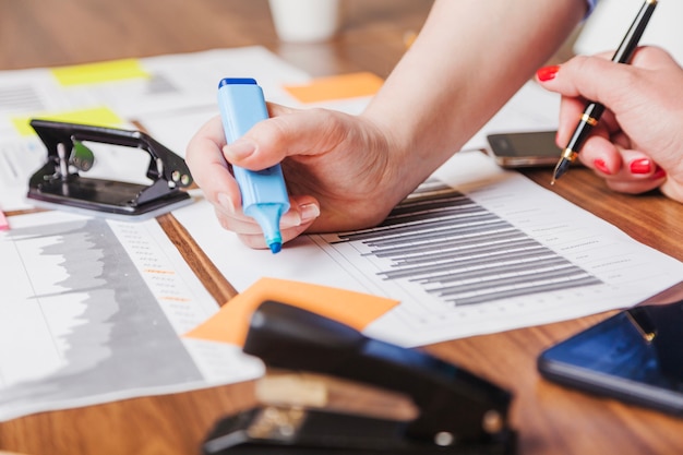 Woman holding marker pen leaning on desk