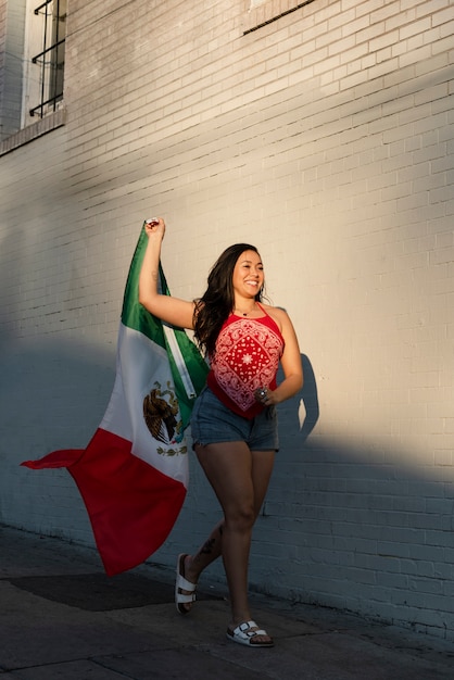 Free photo woman holding mexican flag in the street