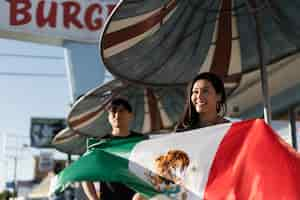 Free photo woman holding mexican flag in the street