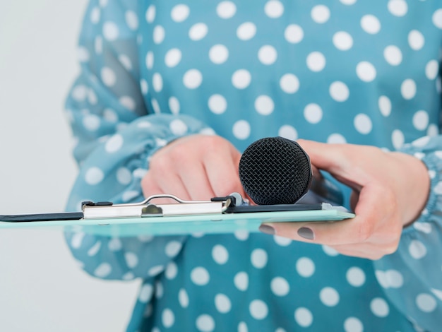 Free Photo woman holding microphone and clipboard